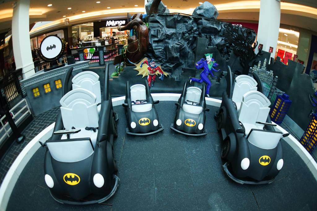WOF03565 Carrinhos elétricos pretos com o símbolo do batman estão estacionados em um cenário do filme do personagem no shopping Mooca Plaza