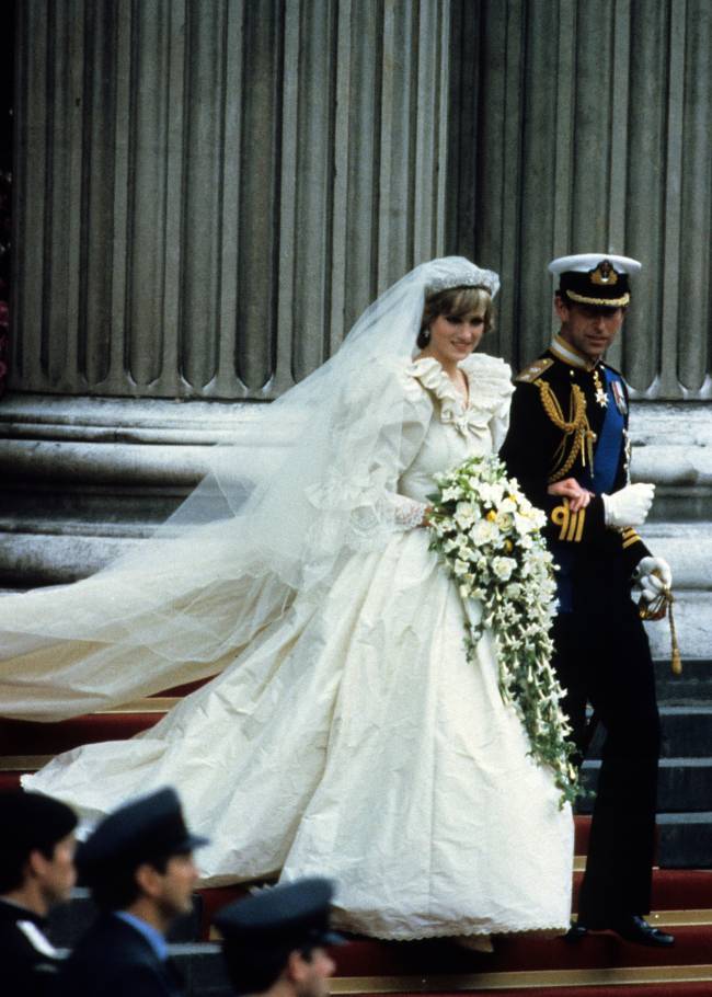 40-anos-casamento-principe-charles-princesa-diana-cerimonia-saida-igreja-close.jpg close do príncipe charles e da princesa diana descendo as escadas da igreja após sua cerimônia de casamento. no primeiro plano, guardas enfileirados pela escada desfocados