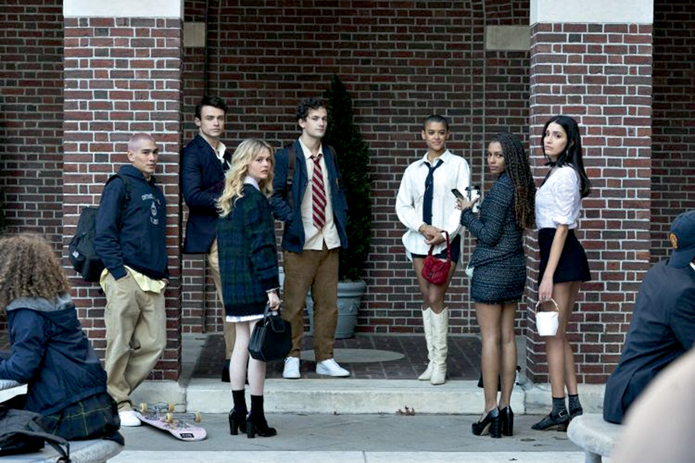 A imagem mostra os sete novos personagens de Gossip Girl, posando com roupas chiques, olhando para a câmera
