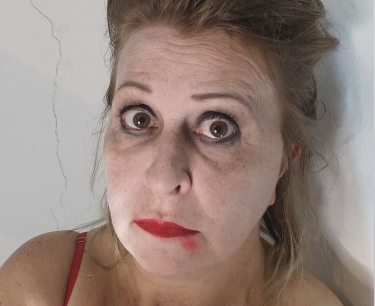 Mulher com olhos arregalados está olhando para câmera com a maquiagem borrada