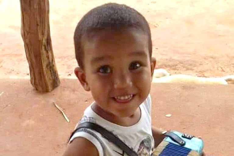 A imagem mostra o rosto de Alex, sorrindo com um brinquedo na mão.