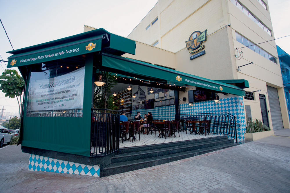 BARDOJUAREZlm6.jpg A imagem mostra mostra o bar do Juarez em uma esquina, com o toldo aberto para a rua.