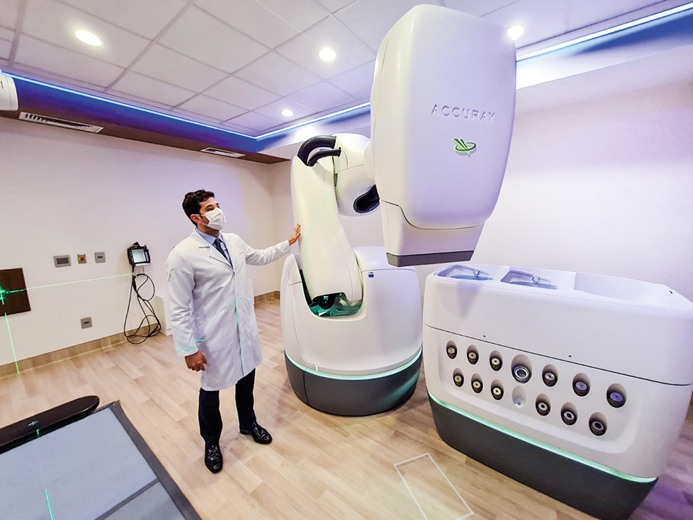 Cyberknife vila nova star A imagem mostra uma grande máquina branca de uns 3 metros conhecida como Cyberknife.