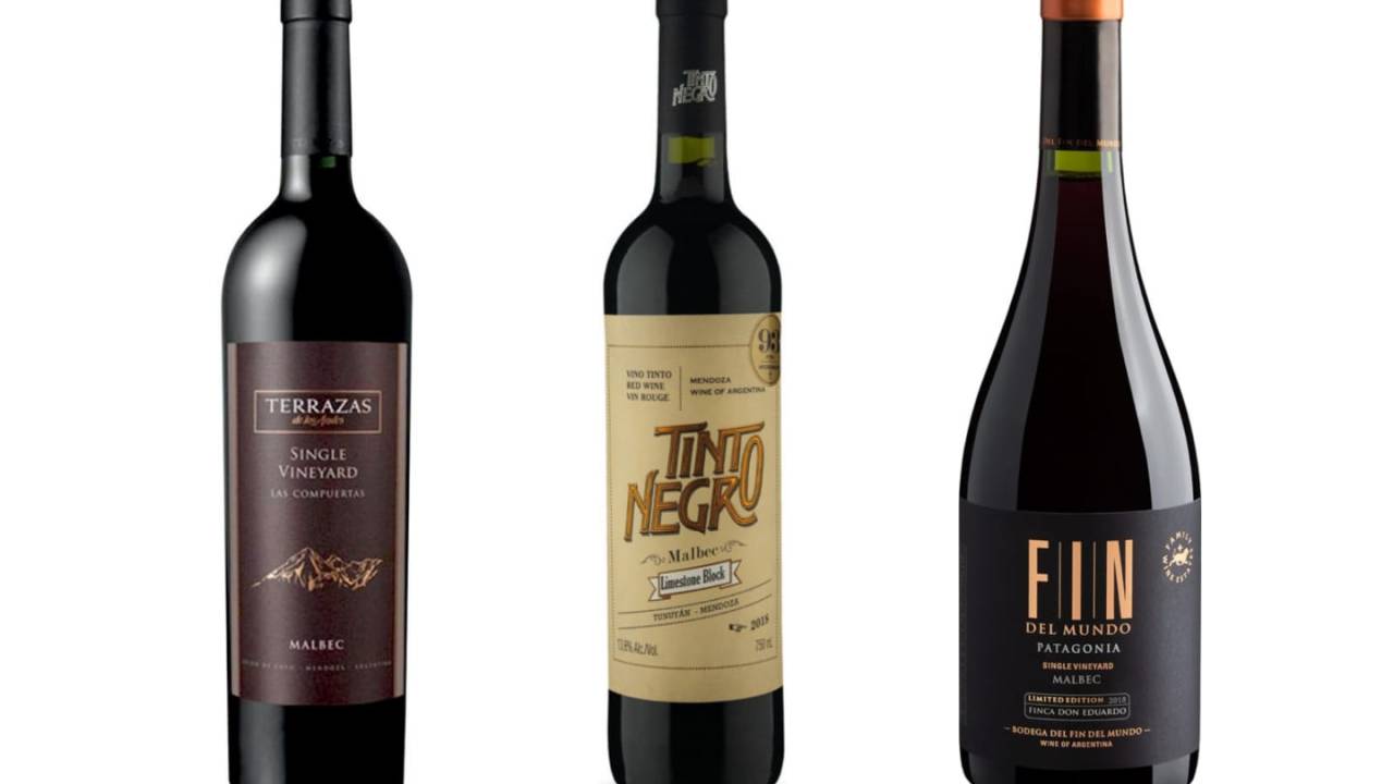 Três garrafas de vinhos tintos sobre fundo branco