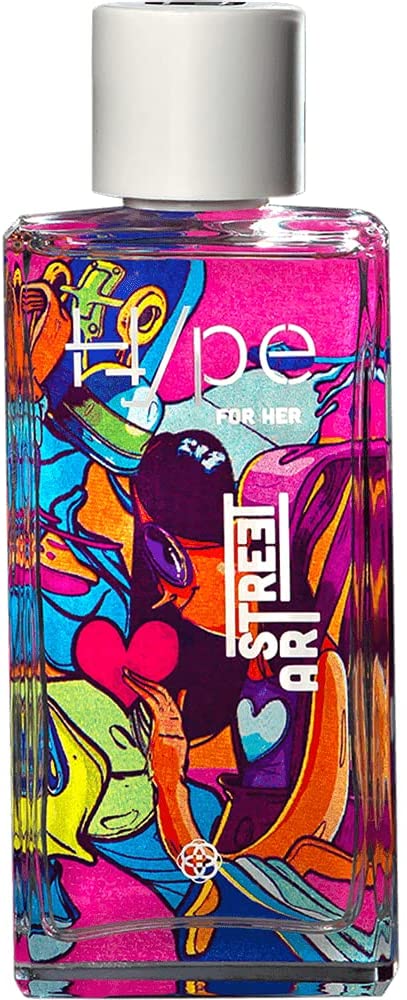 hinode Frasco de perfume de vidro transparente e, ao fundo, uma arte super colorida como se fosse em grafite, dá para ver uma menina pintada
