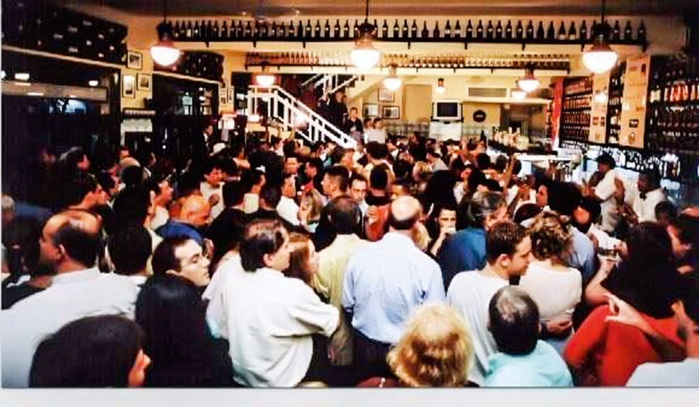inauguração público.jpg A imagem mostra a filial lotada de pessoas durante a noite.