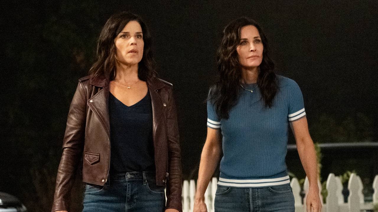 A imagem mostra as atrizes Neve Campbell (Sidney Prescott) e Courteney Cox (Gale Weathers), estrelas de Pânico, olhando assustadas para algo