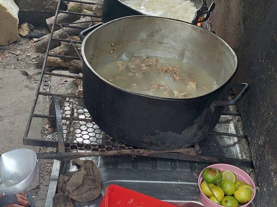 A foto mostra panelas com comida em local sem higiene