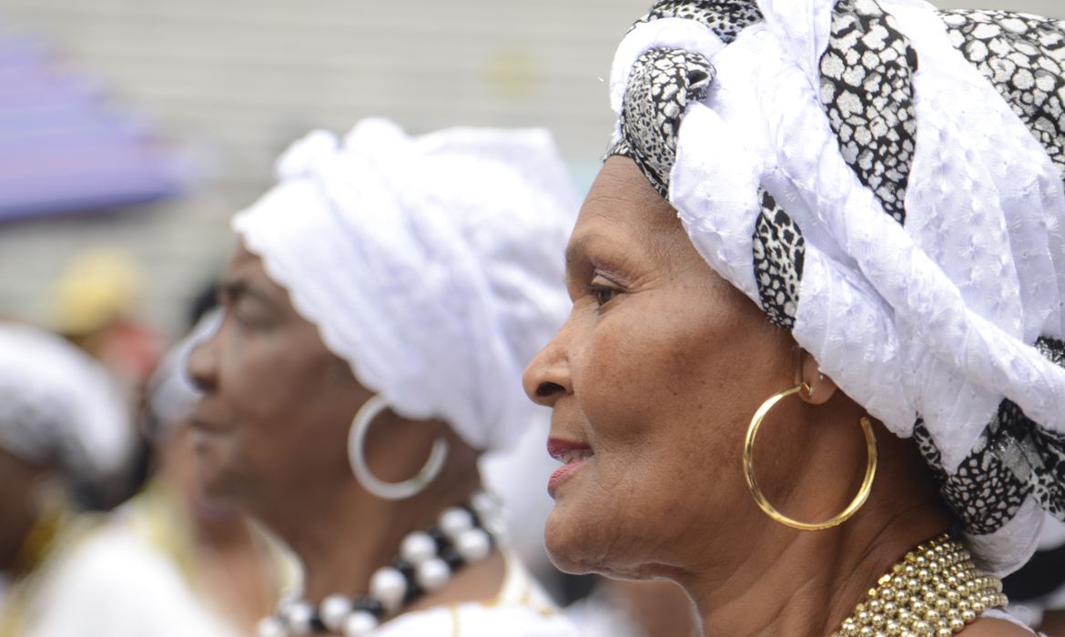 Imagem mostra duas mulheres de turbantes e brincos