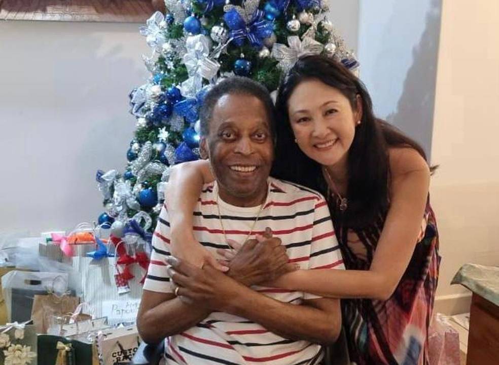 imagem mostra Pelé, de camiseta listrada, abraçado à esposa