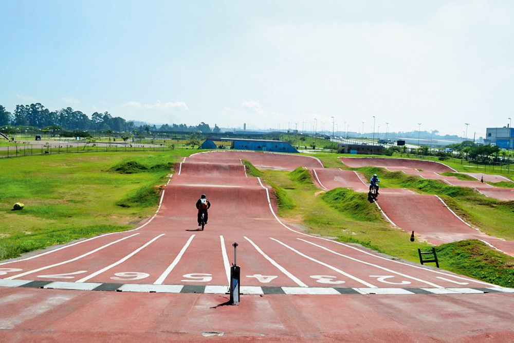 01 Parque Jacuí_Divulgação_Secretaria-Meio-Ambiente.jpeg Imagem mostra pista avermelhada com um motociclista dirigindo em uma das raias.