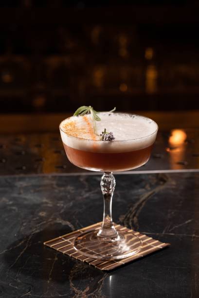 Fuego: rum, limão-siciliano, mel de agave, licor Saint Germain, clara e spray de Chartreuse flambado Fuego: rum, limão-siciliano, mel de agave, licor Saint Germain, clara e spray de Chartreuse flambado