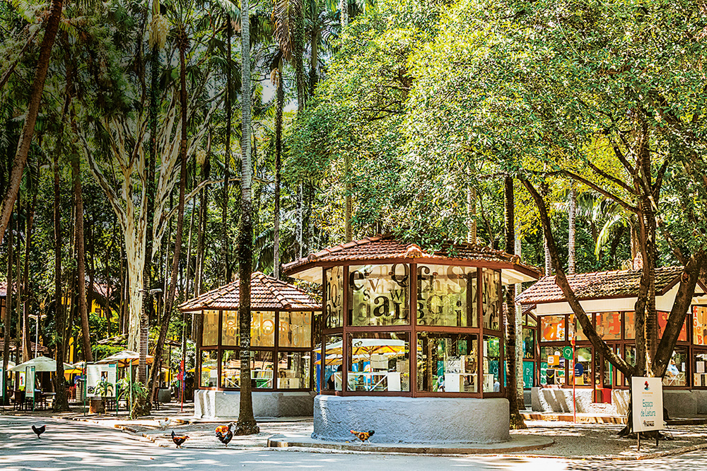 Espaço de Leitura no Parque da Água Branca. Imagem mostra árvores e pequenas construções em formato cilíndrico.