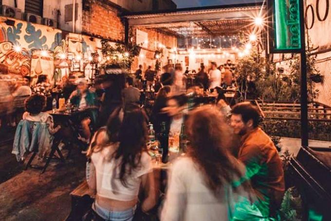 Ambiente iluminado por lâmpadas suspensas e com paredes decoradas por grafites