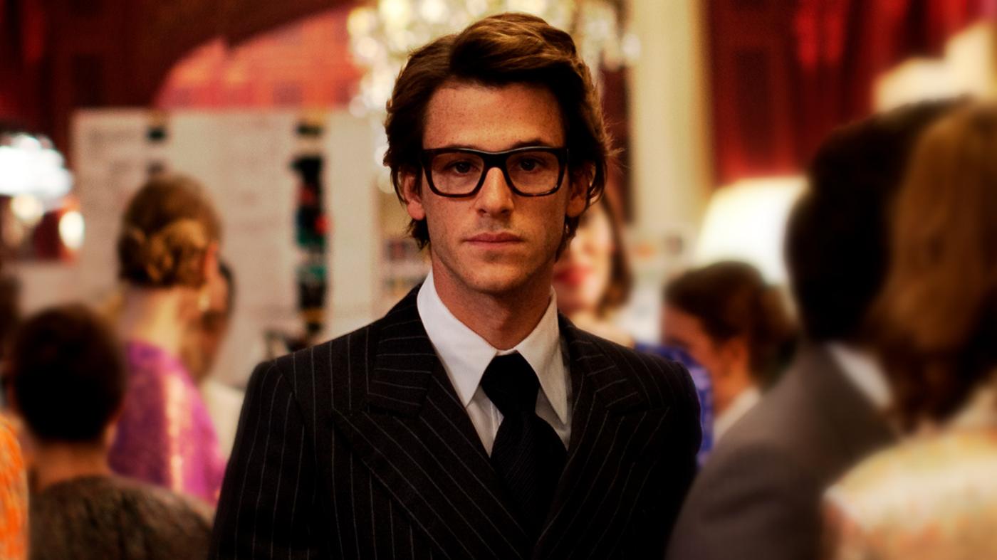 Imagem mostra homem de terno e &oacute;culos.