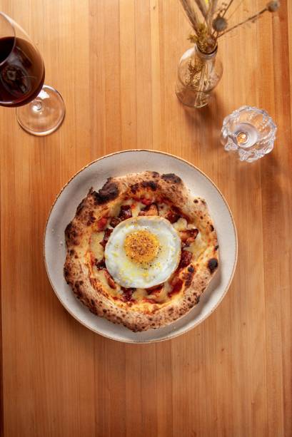 Pizza carbonara: queijo muçarela, ovo com gema mole, bacon, raspas de limão-siciliano e pimenta-preta