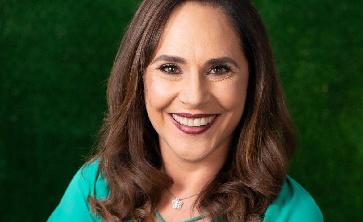Sofia Esteves, fundadora do Instituto Ser +, sorri para a foto e veste blusa azul-turquesa. Tem cabelos longos castanhos.