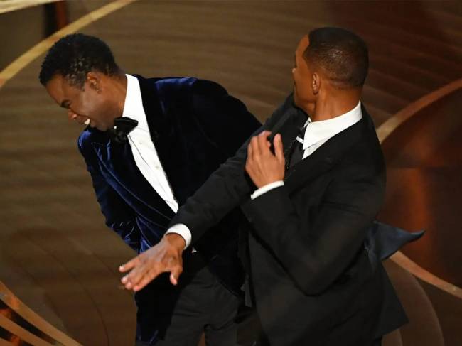 A imagem mostra Will Smith dando um tapa em Chris Rock