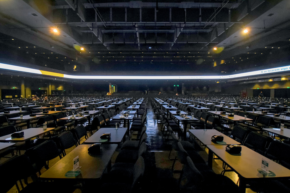 Imagem mostra interior de casa de shows, com diversas mesas.