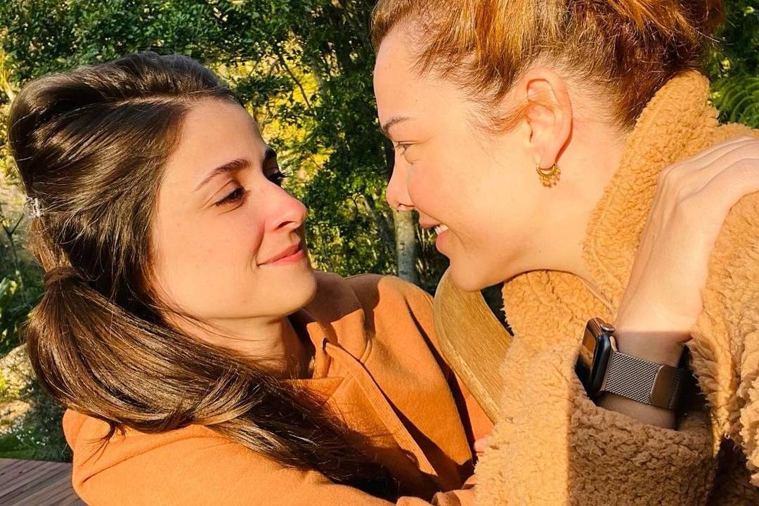 Imagem de Fernanda Souza abraçada e olhando para Eduarda