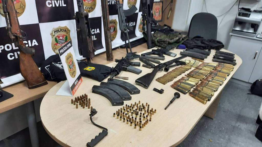 Armas apreendidas pelo Deic em chácara em Araçariguama, no interior de São Paulo, exibidas em mesa.