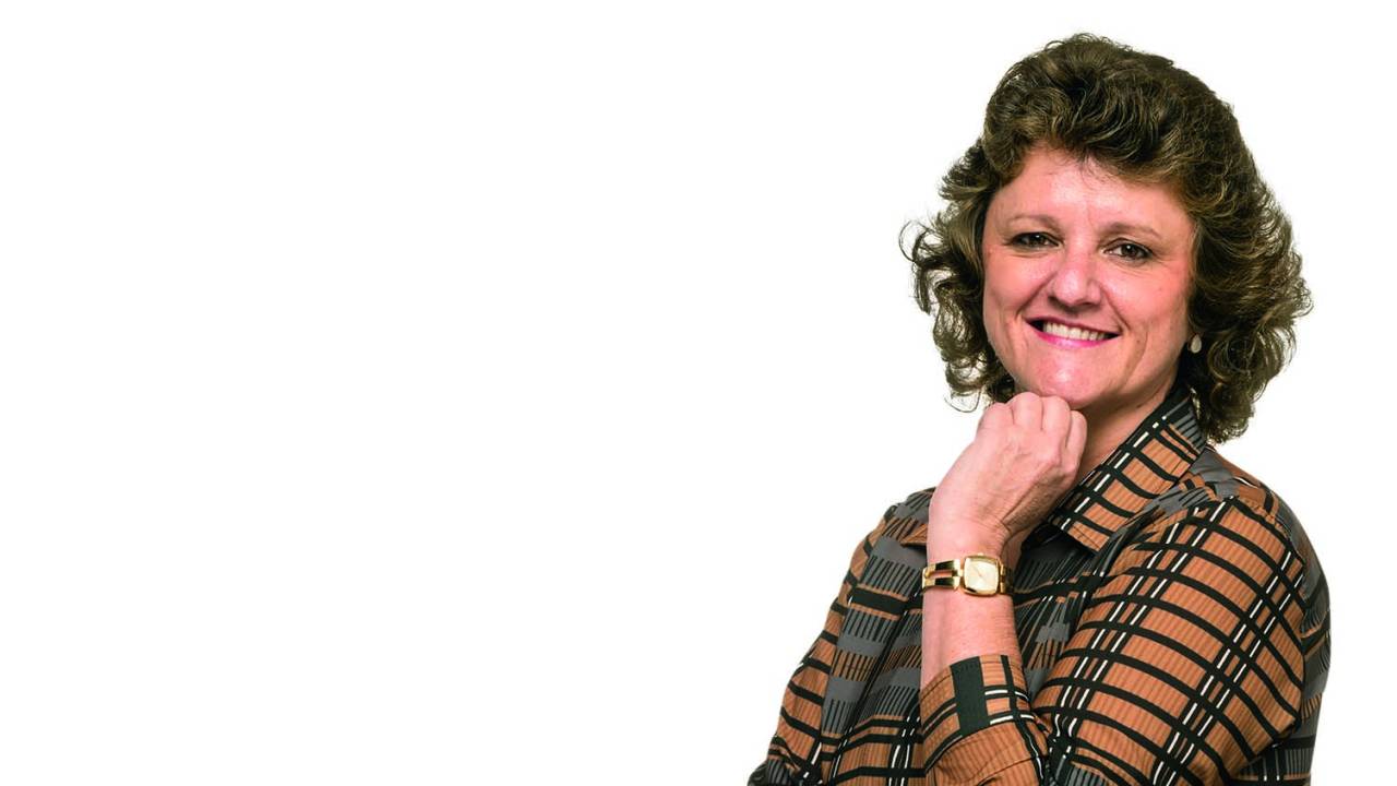 Marcia Auriani, coordenadora a do curso debranding e marketing, posa sorrindo e com a mão no queixo