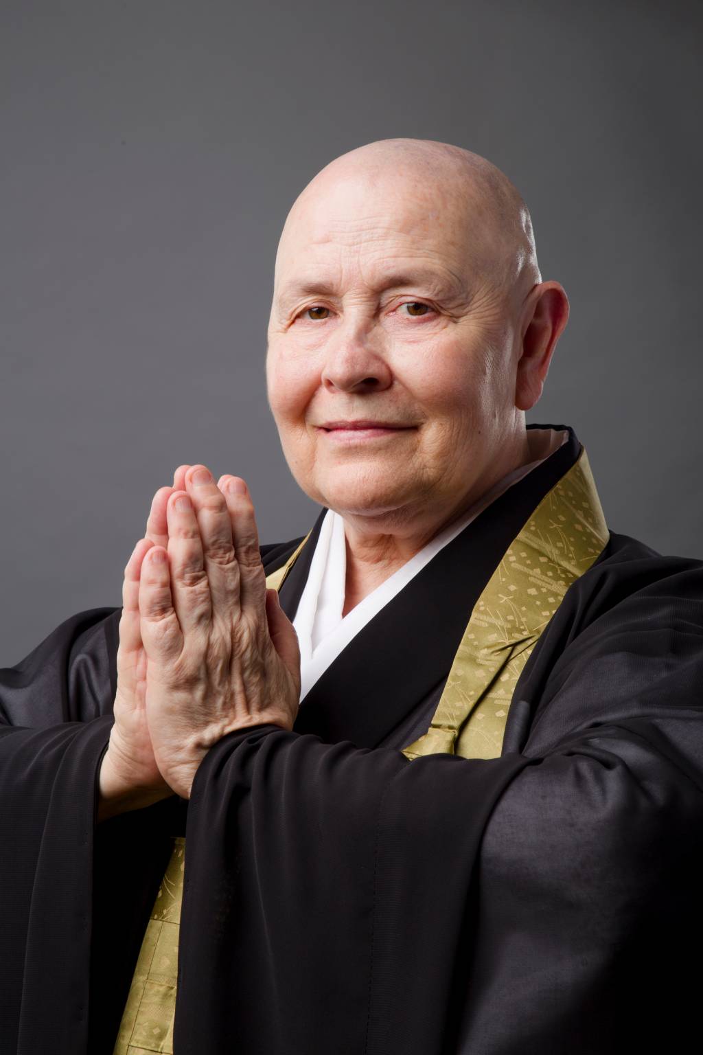 Monja Coen Roshi (ANDRÉ GENZO SPINOLA E CASTRO-DIVULGAÇÃO) (5) Com as palmas em sinal de oração, Monja Coen encara a câmera e veste quimono preto.