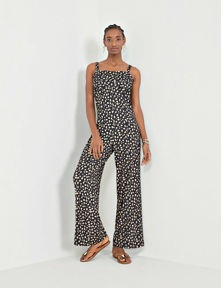 Modelo negra e magra usa macac&atilde;o preto e branco com estampa de leopardo e posa em frente a um fundo branco