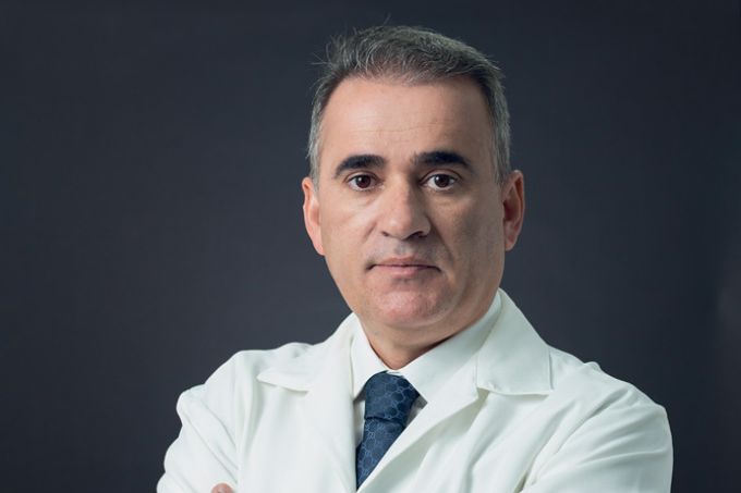 Cid Pitombo aparece de jaleco, posando com os braços cruzados