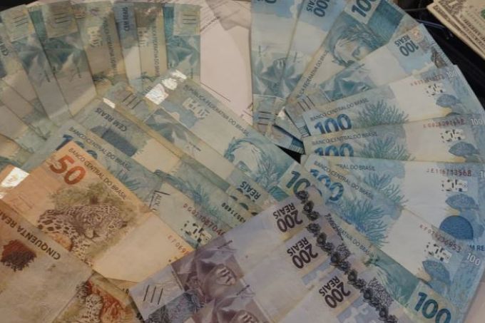 Foram apreendidos o equivalente a 90 000 reais, divididos entre reais (30 000) e dólares (12 000)
