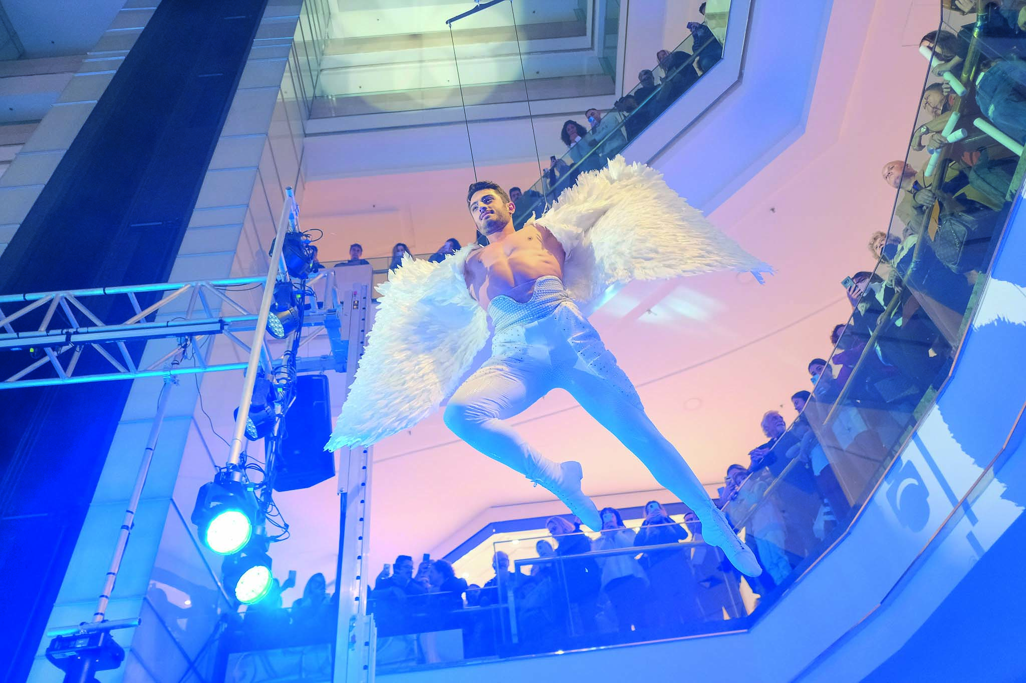 Imagem mostra homem vestido de anjo suspenso em v&atilde;o de shopping.
