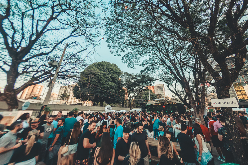 Foto de público em jardim com árvores ao ar livre.