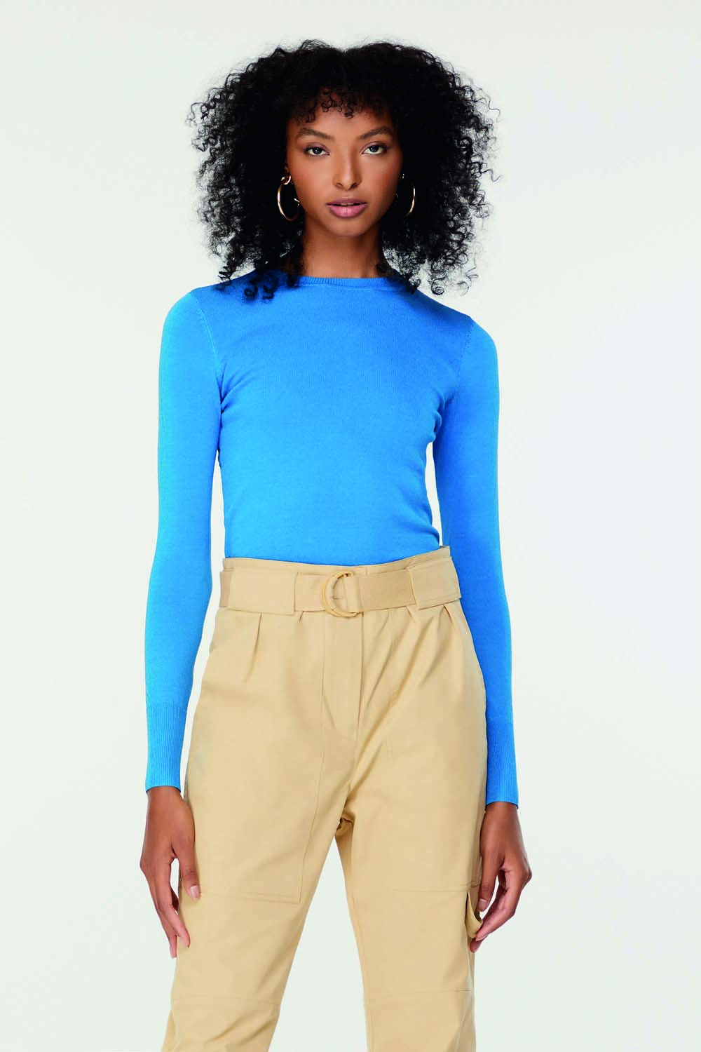 Imagem mostra mulher com blusa de tricot azul clara