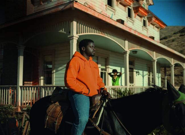 nao nao olhe – credito UNIVERSAL STUDIOS.jpg Imagem mostra homem vestindo casaco laranja e calça jeans em cima de cavalo