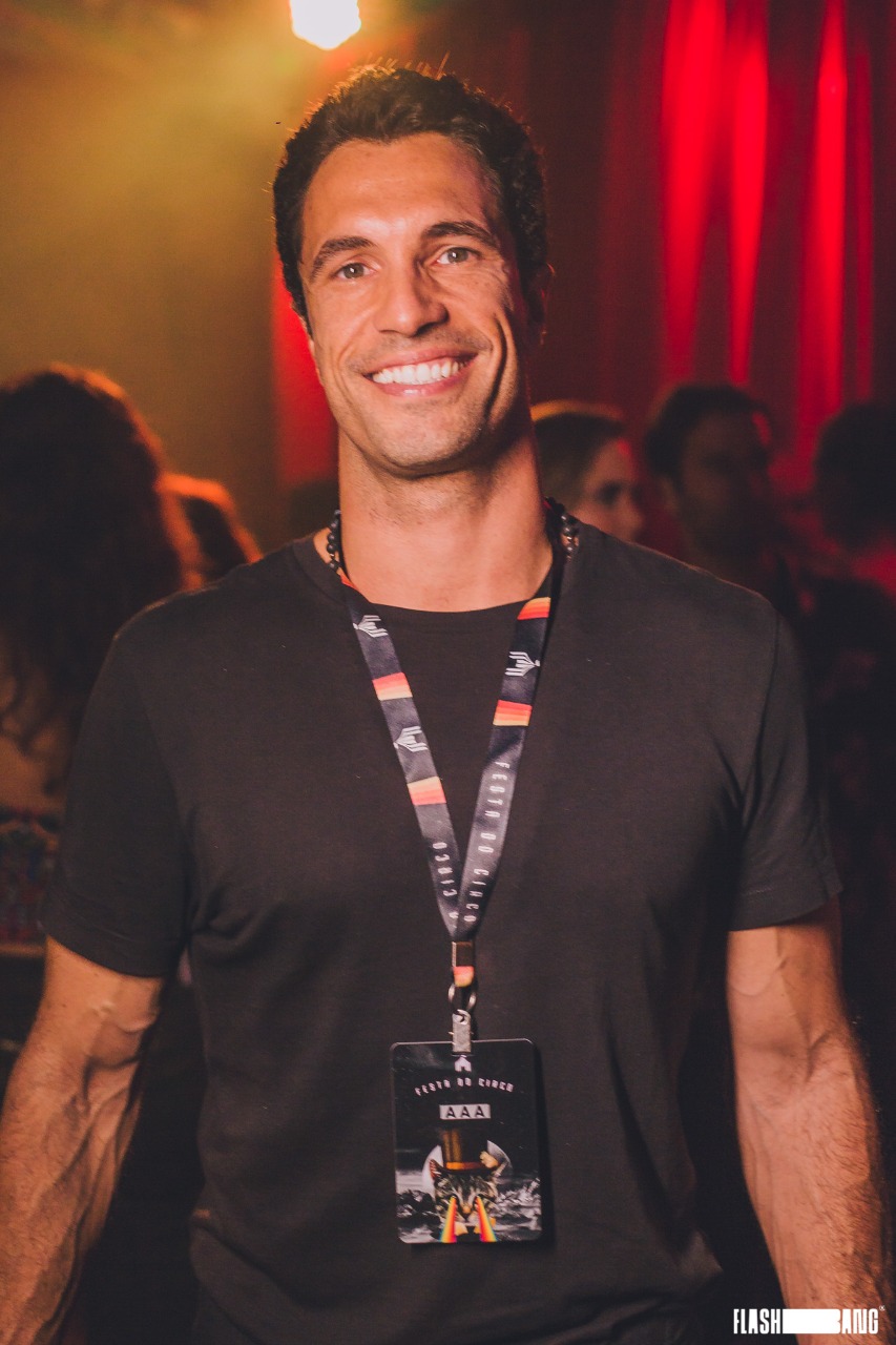 Flavio Sarahyba (Fred Pontes-Divulgação) Flavio Sarahyba sorri para a foto e veste camiseta preta com crachá no pescoço.