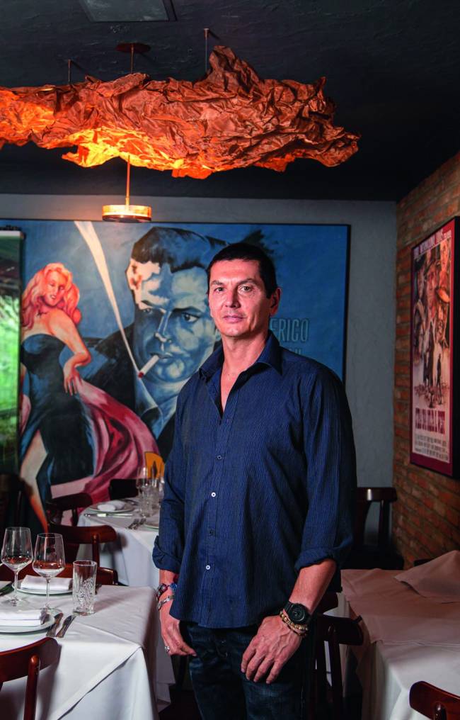 o socio Gianluca Perino_2.jpg Homem de camisa azul escura em ambiente interno em frente a um quadro
