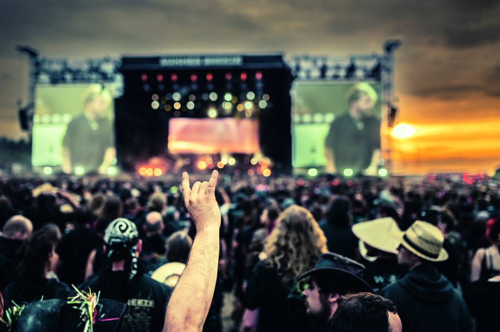 Summer Breeze Imagem mostra mão fazendo sinal de rock'and'roll em meio a multidão, Ao fundo, desfocado, um palco