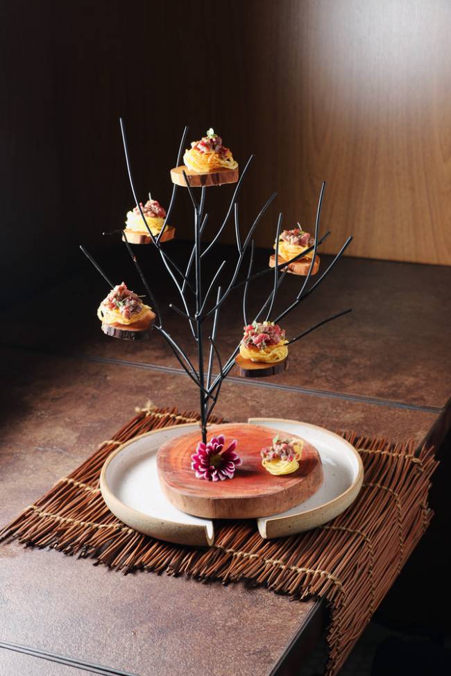 Tartare Canto do Picuí Árvore de metal com prateleiras pequenas onde estão as cestinhas comestíveis com o steak
