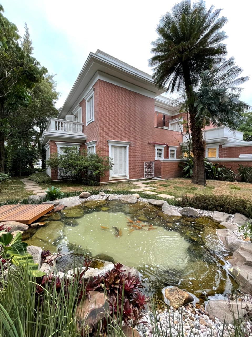 Núcleo GA – Jardins (Arquivo Pessoal) (1) Em primeiro plano, foto exibe lago de carpas com mansão de cor amarronzada ao fundo.