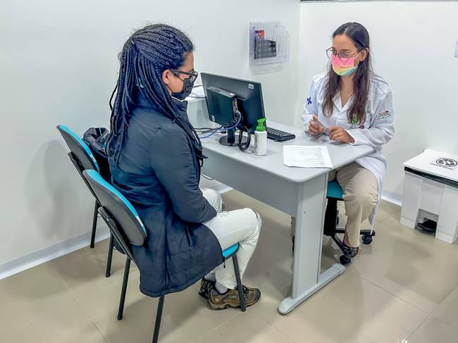 Foto do consultório mostra médica atenden paciente