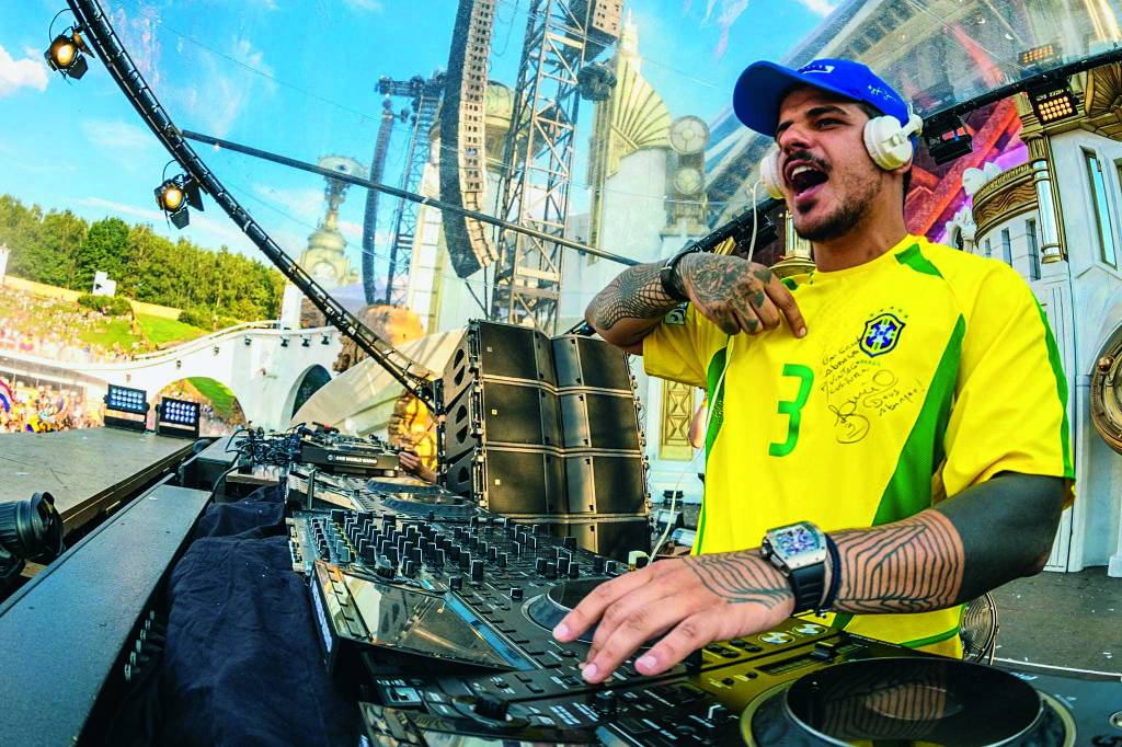Vintage Culture Imagem mostra DJ com camisa do Brasil tocando em palco