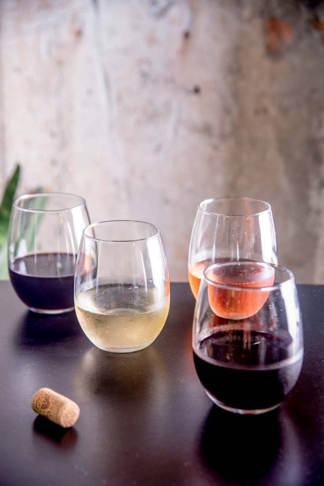 Enoteca Nacional vinhos copo Quatro copos com vinhos distintos sobre mesa preta laqueada