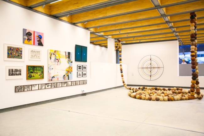 Pina Contemporânea Sala branca com exposição artística: quadros na parede da esquerda e diversas bolas empilhadas no canto direito