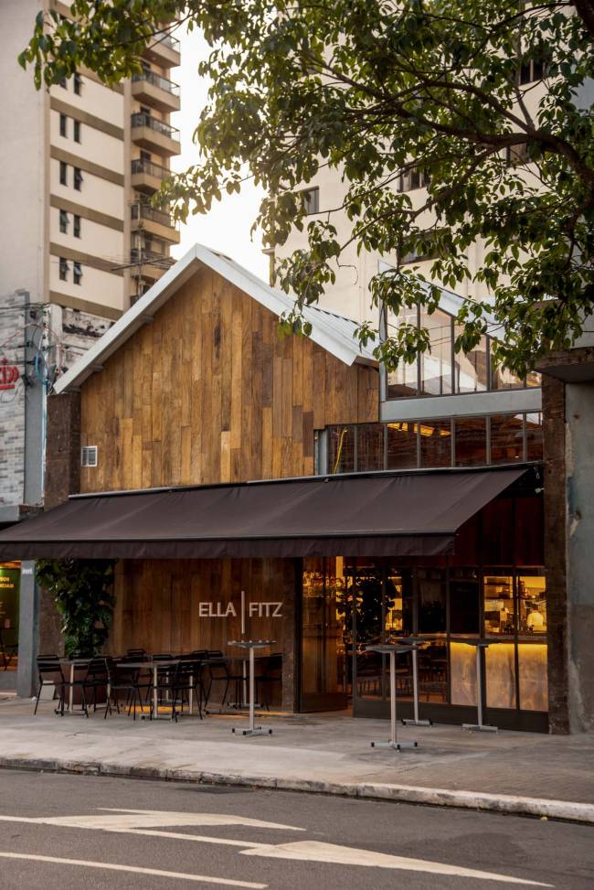 Ella Fitz fachada Fachada de madeira com toldo marrom que lembra galpão industrial novaiorquino