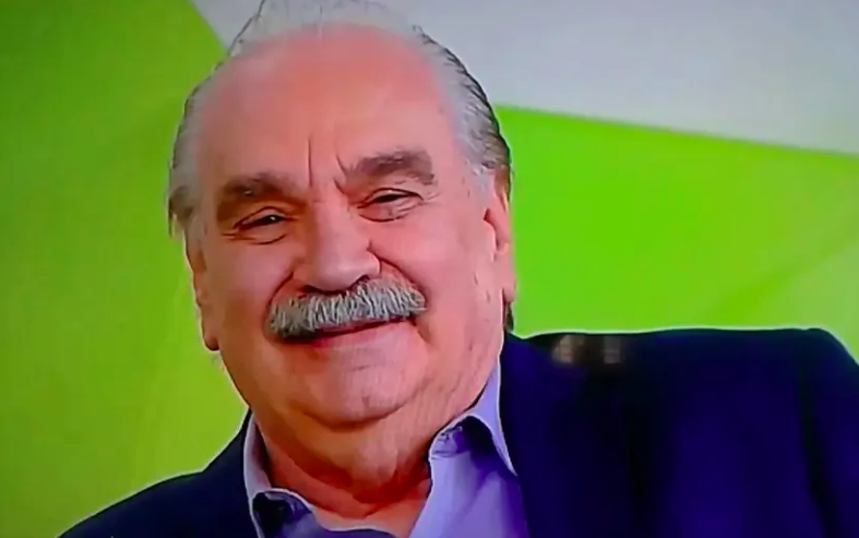 um homem de cabelos e bigode grisalhos sorrindo