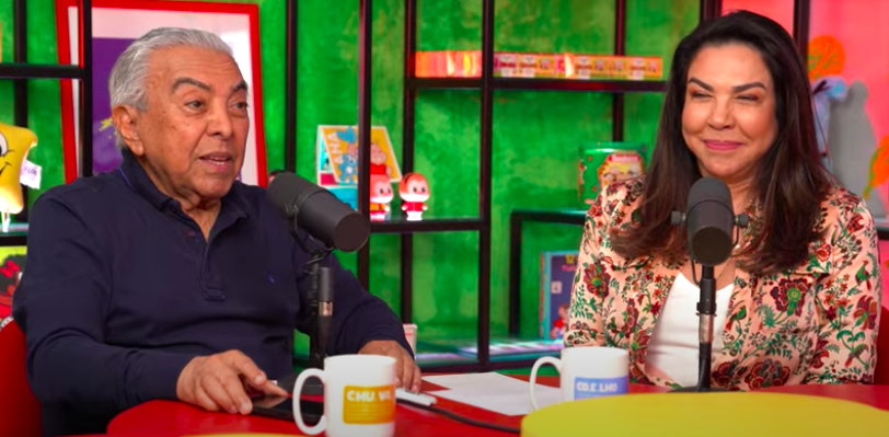 Mauricio de Sousa e Mônica sentados na bancada de um podcast
