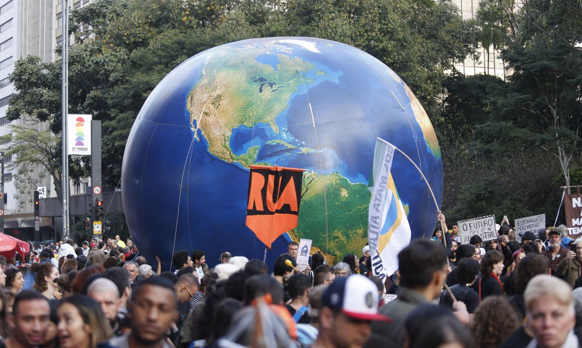 pessoas na rua e um grande globo terrestre inflável entre elas