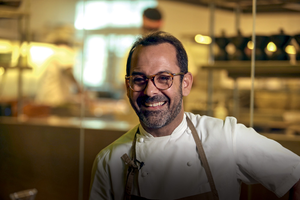 Chef de avental sorrindo.