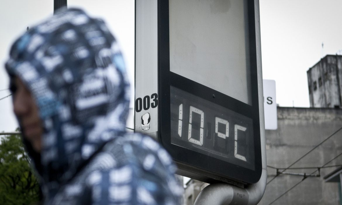 a imagem mostra uma pessoa encapuzada e um termômetro de rua apontando 10ºC