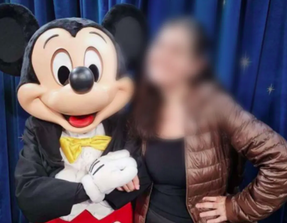 uma pessoa vestida de mickey abraçado a uma jovem